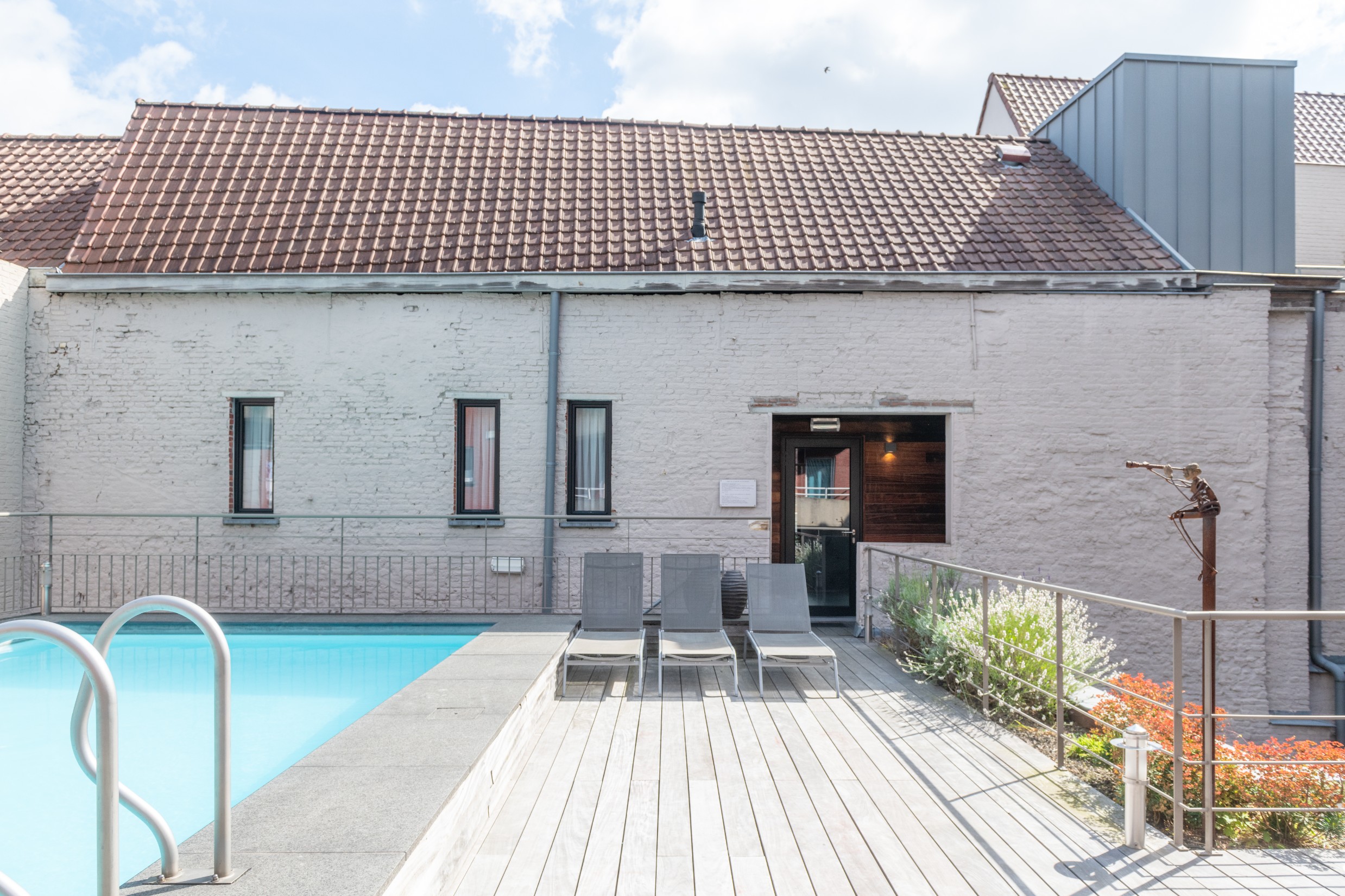 Zwembadterras met ligstoelen aan het buitenzwembad